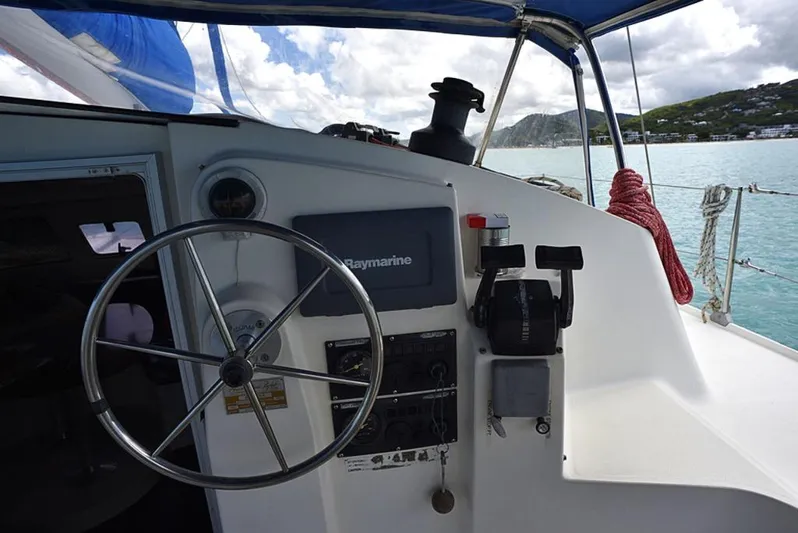 Mersea Yacht Photos Pics Helm of 1997 Fountaine Pajot Athena 38 catamaran with steering wheel and navigation equipment.