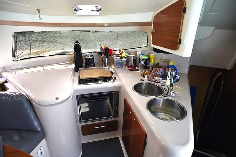 Mersea Yacht Photos Pics Compact kitchen in a 1997 Fountaine Pajot Athena 38 catamaran, featuring dual sinks and modern appliances.
