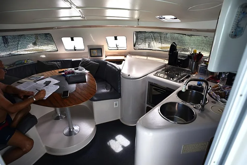 Mersea Yacht Photos Pics Interior of 1997 Fountaine Pajot Athena 38 catamaran with kitchen and seating area.