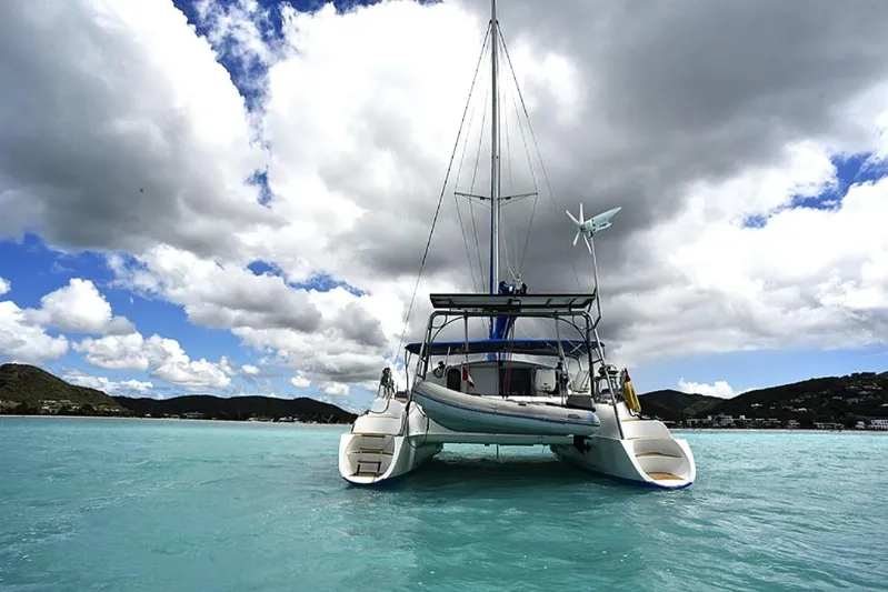 Mersea Yacht Photos Pics Fountaine Pajot Athena 38 catamaran sailing on turquoise waters under a cloudy sky.