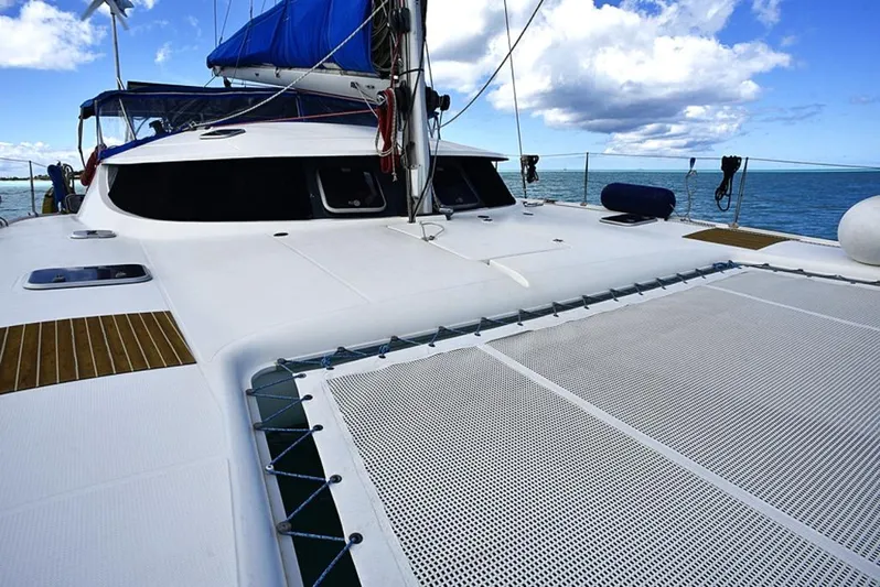 Mersea Yacht Photos Pics 1997 Fountaine Pajot Athena 38 catamaran with blue sails on open water under a cloudy sky.