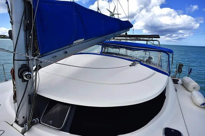 Mersea Yacht Photos Pics Sailing catamaran Fountaine Pajot Athena 38, 1997 model, with blue sail cover on open water.
