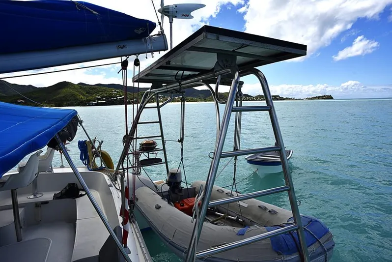 Mersea Yacht Photos Pics Fountaine Pajot Athena 38 catamaran with dinghy, anchored in serene blue waters, 1997 model.