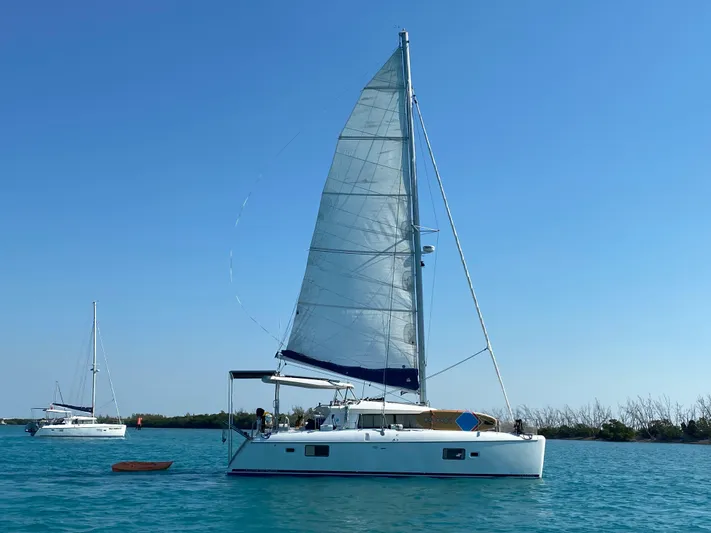 Hh Sound Waves Yacht Photos Pics 2008 Lagoon 420 Hybrid sailboat on calm blue water under clear sky.