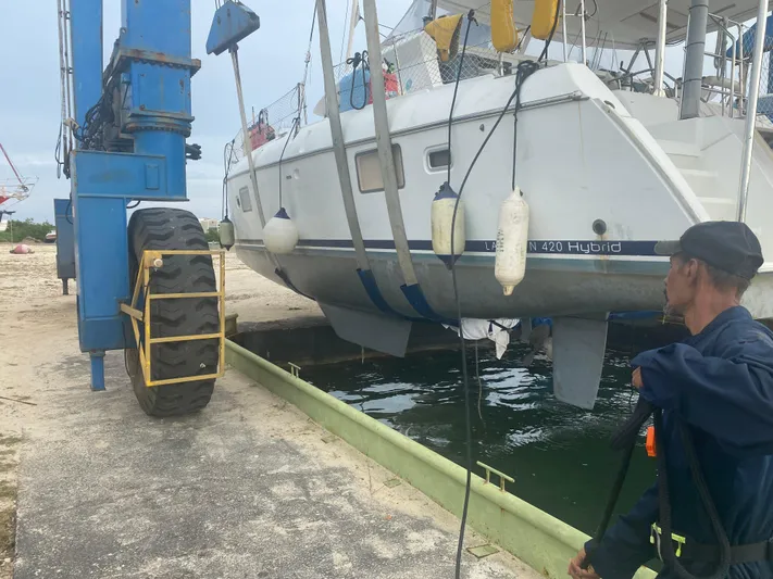 Hh Sound Waves Yacht Photos Pics A 2008 Lagoon 420 Hybrid catamaran being lifted by a blue crane at a dock.