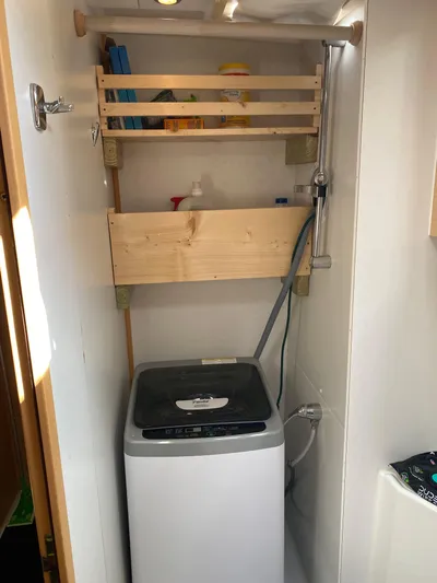 Hh Sound Waves Yacht Photos Pics Laundry area in 2008 Lagoon 420 Hybrid with washing machine and wooden shelves.