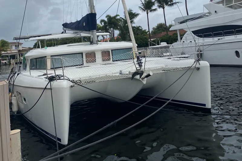 Hh Sound Waves Yacht Photos Pics 2008 Lagoon 420 Hybrid catamaran docked in a marina with palm trees in the background.
