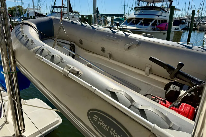 Way Maker Yacht Photos Pics Inflatable boat docked at marina, surrounded by yachts, under clear blue sky.