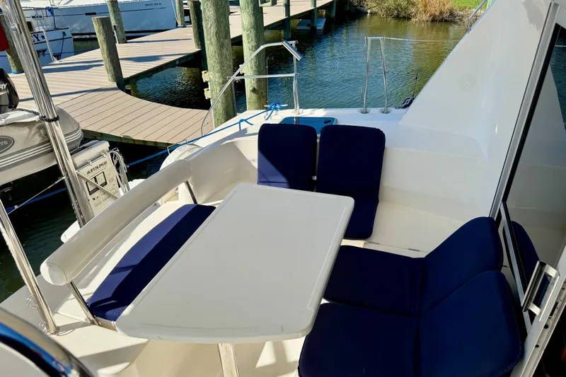 Way Maker Yacht Photos Pics Outdoor seating area on a 2010 Leopard 38 catamaran, featuring blue cushions and a white table.