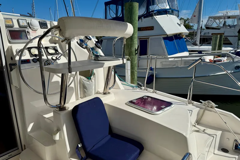 Way Maker Yacht Photos Pics 2010 Leopard 38 yacht cockpit with steering wheel, navigation instruments, and blue cushioned seat.