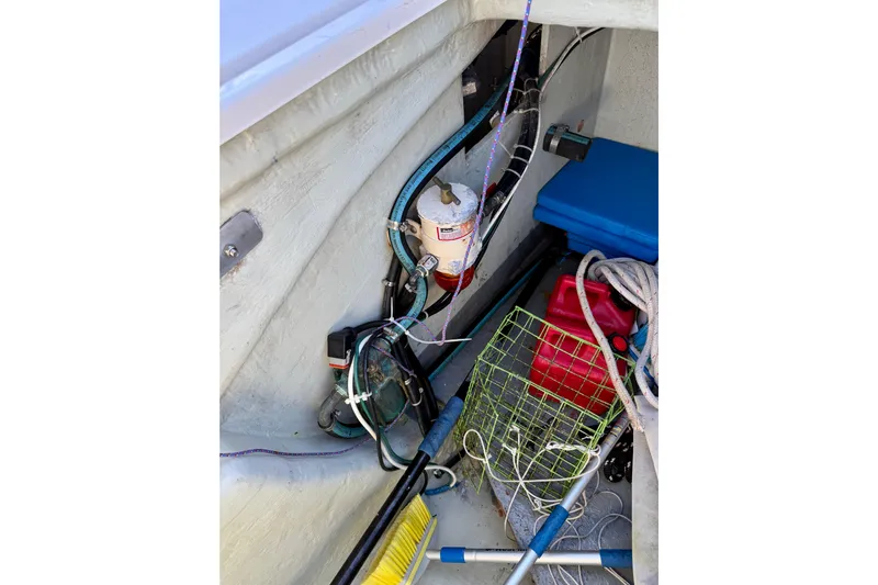 Way Maker Yacht Photos Pics Storage compartment of a 2010 Leopard 38 boat with ropes, fuel can, and cleaning tools.