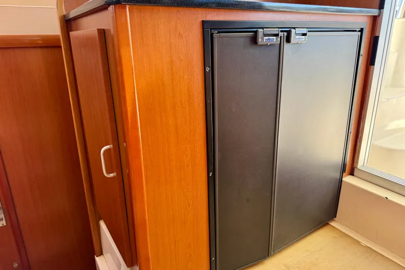 Way Maker Yacht Photos Pics Wooden cabinet with black double-door fridge in 2010 Leopard 38 yacht interior.