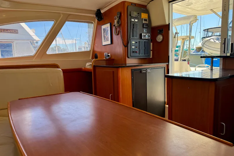 Way Maker Yacht Photos Pics Interior of 2010 Leopard 38 yacht with wooden table, control panel, and marina view.
