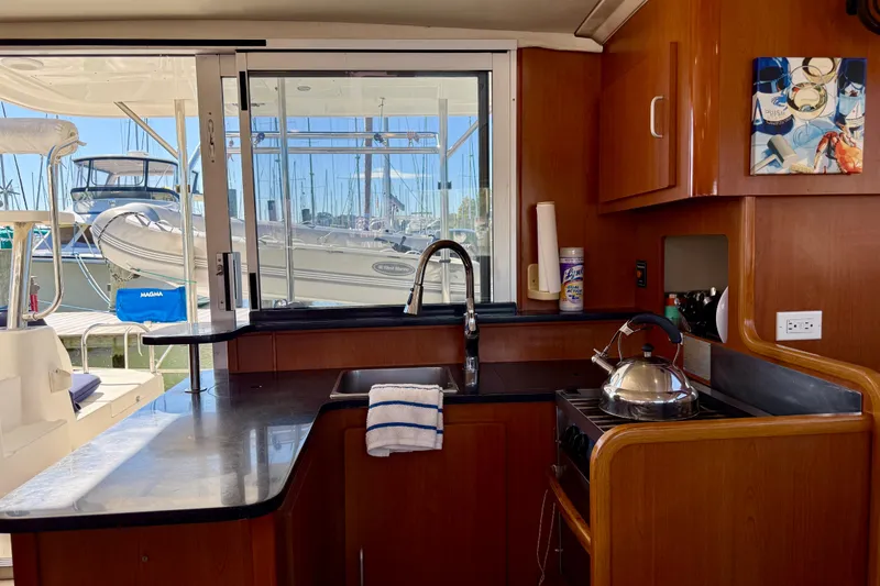 Way Maker Yacht Photos Pics Interior of 2010 Leopard 38 yacht kitchen with wooden cabinetry and marina view.