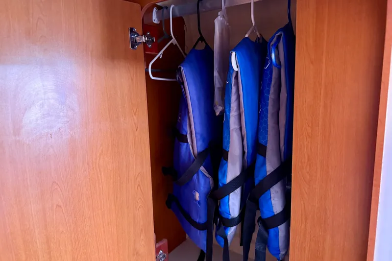 Way Maker Yacht Photos Pics Open wooden cabinet with blue life jackets hanging inside, Leopard 38, 2010 model.