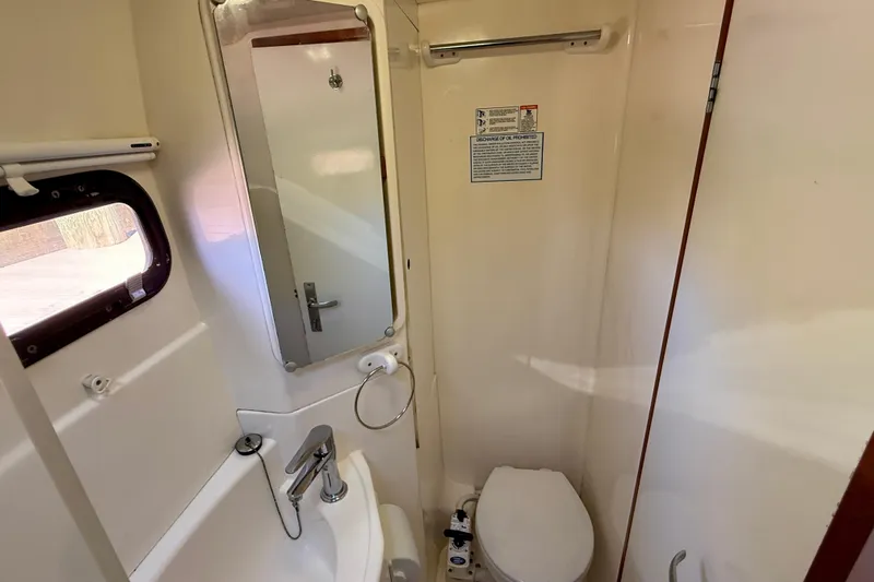 Way Maker Yacht Photos Pics Compact bathroom in a 2010 Leopard 38 yacht, featuring a sink, mirror, and toilet.