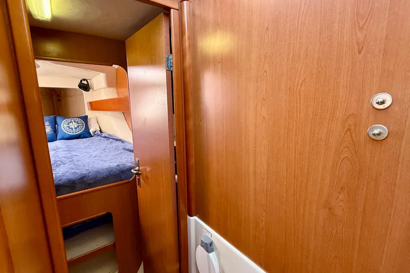 Way Maker Yacht Photos Pics Cozy cabin interior of 2010 Leopard 38 yacht with wooden finish and comfortable bedding.