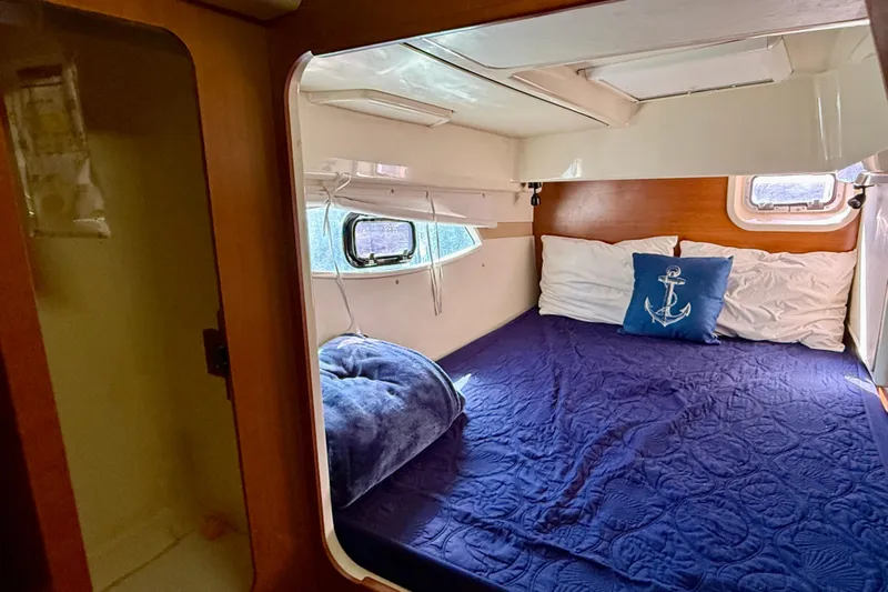 Way Maker Yacht Photos Pics Cozy cabin interior of 2010 Leopard 38 catamaran with nautical-themed bedding.