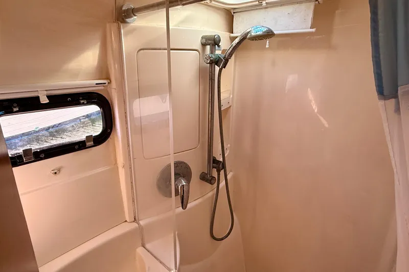 Way Maker Yacht Photos Pics Shower area in a 2010 Leopard 38 yacht, featuring a handheld showerhead and window.