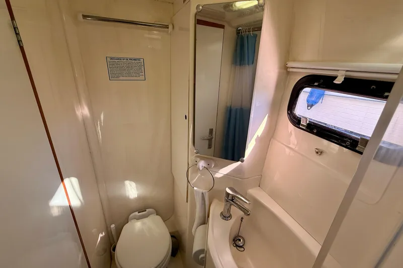 Way Maker Yacht Photos Pics Compact bathroom in a 2010 Leopard 38 yacht with sink, toilet, and window.