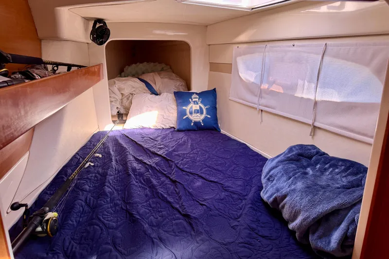 Way Maker Yacht Photos Pics Cozy cabin interior of 2010 Leopard 38 yacht with blue bedding and nautical decor.