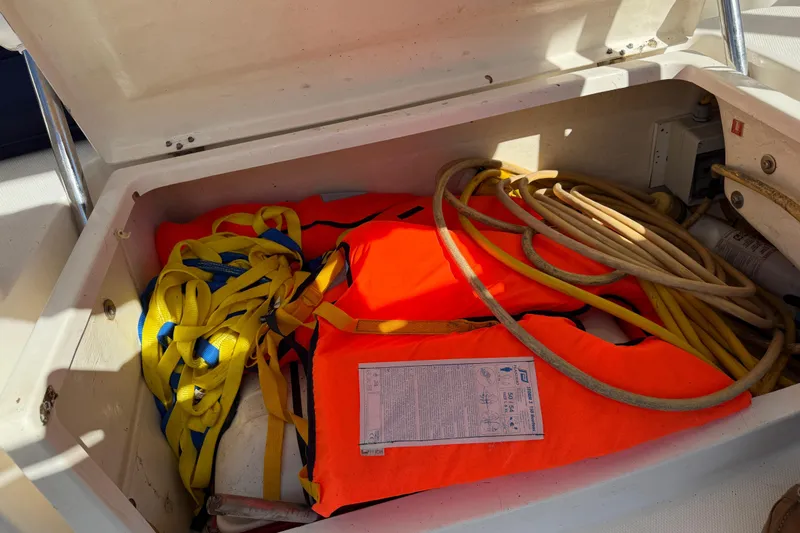 Way Maker Yacht Photos Pics Storage compartment on 2010 Leopard 38 with life jacket, ropes, and safety equipment.