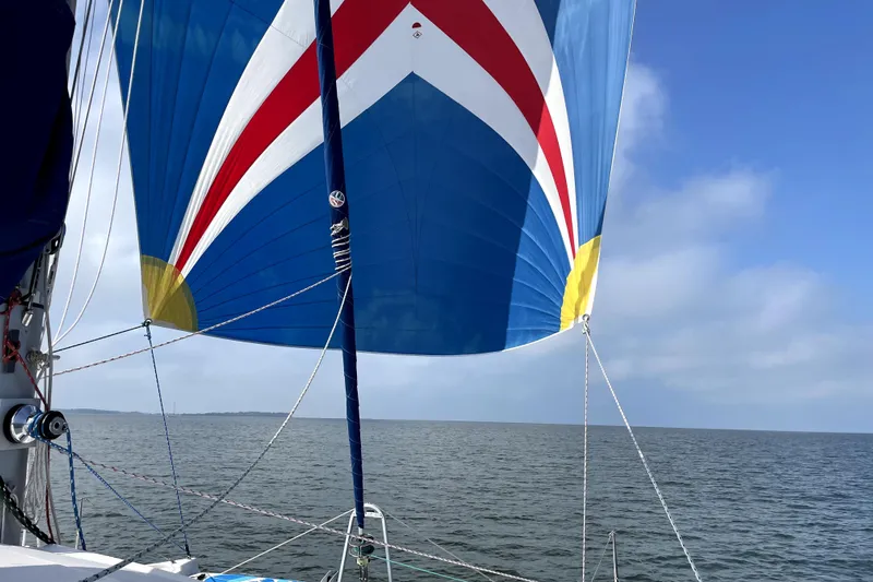 Way Maker Yacht Photos Pics Colorful sail on 2010 Leopard 38 catamaran against blue sky and sea.