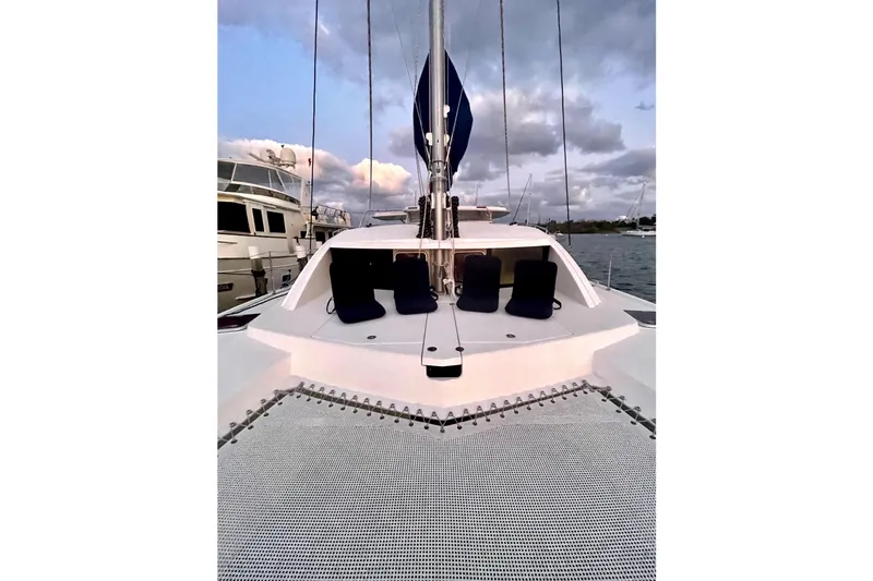 Way Maker Yacht Photos Pics 2010 Leopard 38 catamaran deck with netting and seating, docked at sunset.