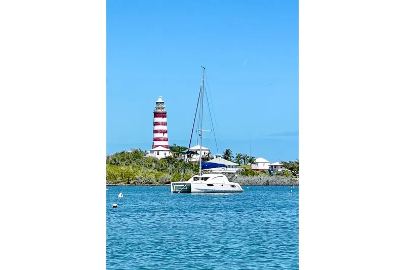 Way Maker Yacht Photos Pics Sailboat Leopard 38 (2010) near striped lighthouse on a sunny day.