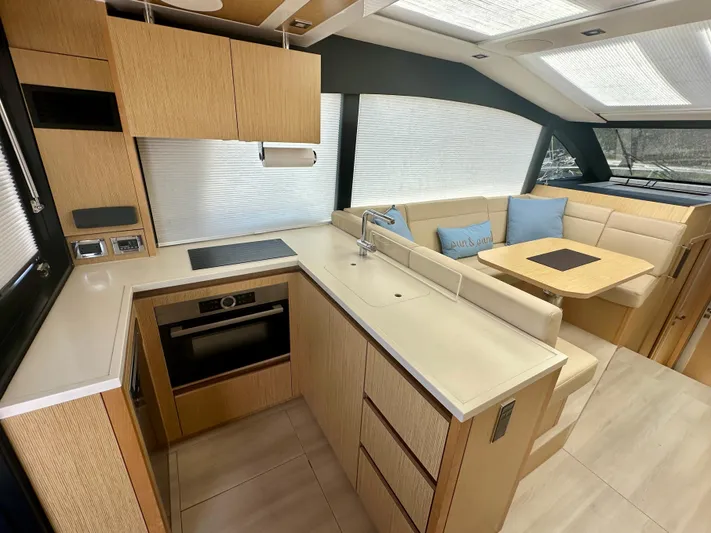 Nan Sea Cay Yacht Photos Pics Modern kitchen and dining area in 2020 Sealine C430 yacht, featuring sleek cabinetry and seating.