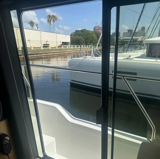 Nan Sea Cay Yacht Photos Pics View from Sealine C430 yacht, overlooking marina with palm trees and buildings.