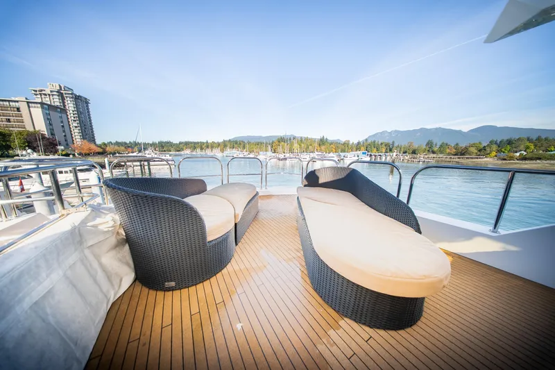 Encore Yacht Photos Pics Luxury yacht deck with wicker seating, scenic waterfront view; Crescent Custom, 1992.