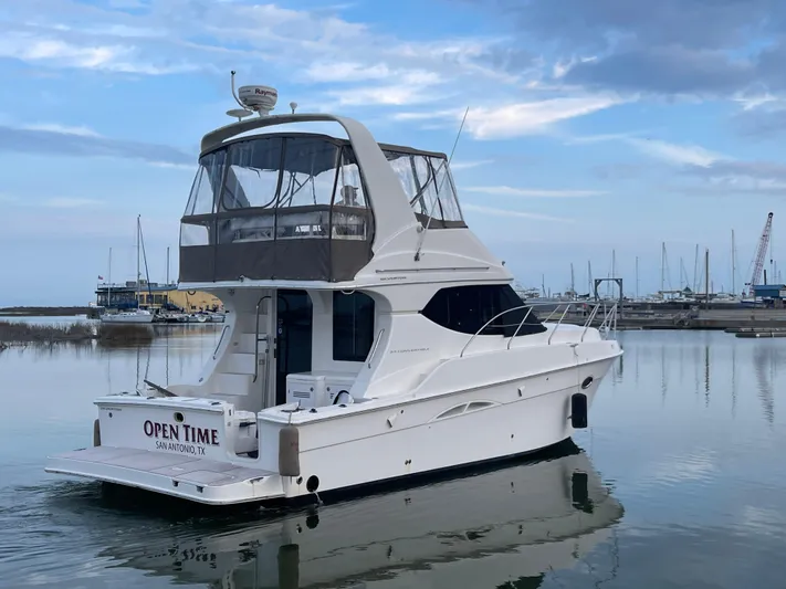 Open Time Yacht Photos Pics 2006 Silverton 34 Convertible yacht docked in a serene marina setting.