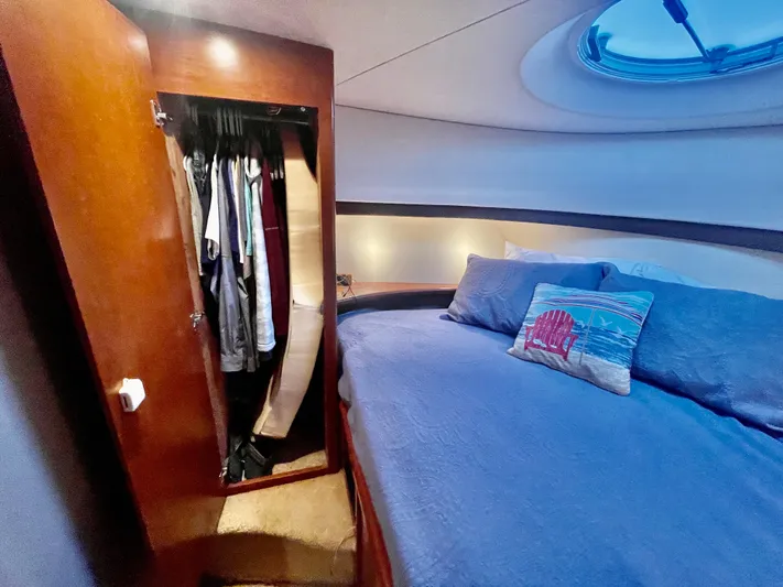 Open Time Yacht Photos Pics Interior cabin of 2006 Silverton 34 Convertible with bed and open wardrobe.