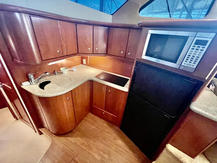 Open Time Yacht Photos Pics 2006 Silverton 34 Convertible yacht kitchen with wood cabinets, microwave, and countertop.
