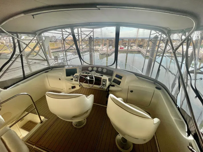 Open Time Yacht Photos Pics 2006 Silverton 34 Convertible yacht cockpit with helm, two seats, and marina view.