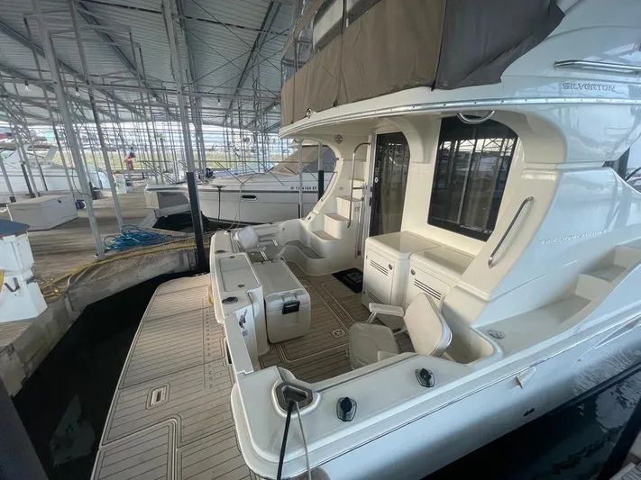 Open Time Yacht Photos Pics 2006 Silverton 34 Convertible yacht docked in a marina, showcasing spacious deck and seating area.