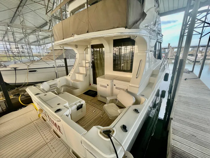 Open Time Yacht Photos Pics 2006 Silverton 34 Convertible yacht docked in a marina, showcasing spacious deck area.