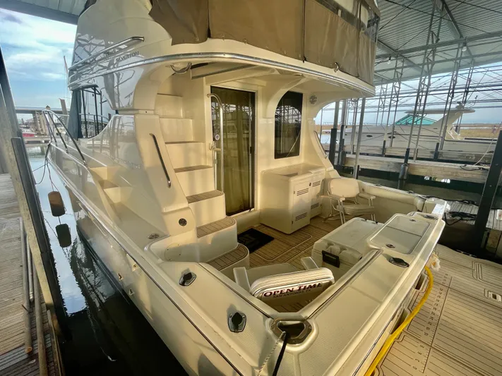 Open Time Yacht Photos Pics 2006 Silverton 34 Convertible yacht docked in marina, showcasing sleek design and spacious deck.