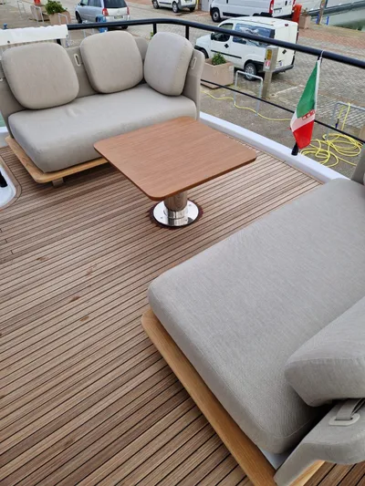  Yacht Photos Pics 2025 Azimut Magellano 60 yacht deck with cushioned seating and wooden table.