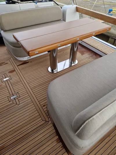  Yacht Photos Pics 2025 Azimut Magellano 60 yacht deck with wooden table and cushioned seating.