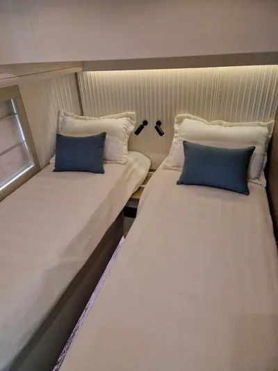  Yacht Photos Pics 2025 Azimut Magellano 60 yacht cabin with twin beds and blue accent pillows.