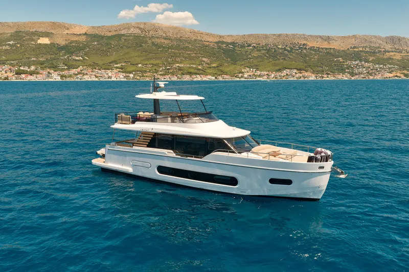  Yacht Photos Pics 2025 Azimut Magellano 60 yacht cruising on blue ocean near scenic coastline.