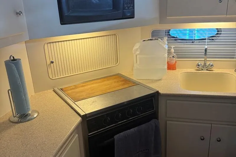  Yacht Photos Pics Compact kitchen in a 1998 Carver 405 Motor Yacht with stove, sink, and microwave.