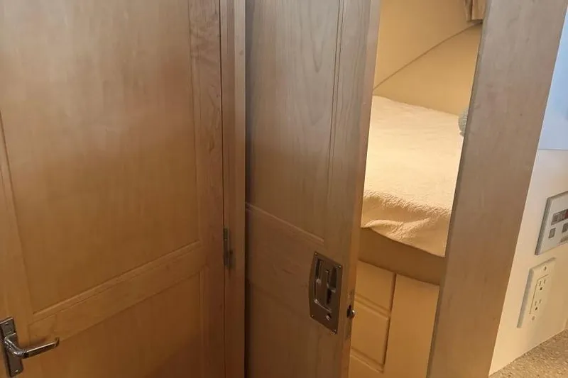  Yacht Photos Pics Interior cabin view of 1998 Carver 405 Motor Yacht with wooden doors and cozy bed.