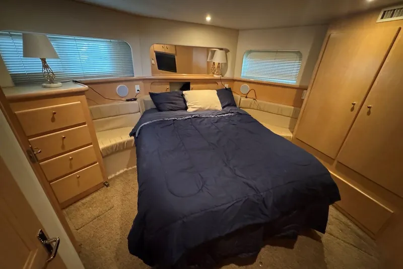  Yacht Photos Pics Luxurious bedroom interior of 1998 Carver 405 Motor Yacht with cozy bed and wooden cabinetry.