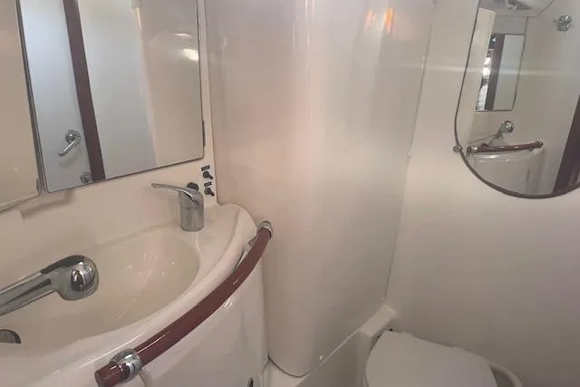 Plein Air Yacht Photos Pics Bathroom interior of 2006 Beneteau 423 yacht with sink, mirror, and toilet.