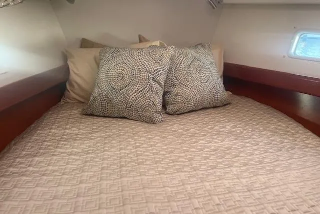 Plein Air Yacht Photos Pics Cozy cabin bed in 2006 Beneteau 423 yacht with patterned pillows and soft lighting.