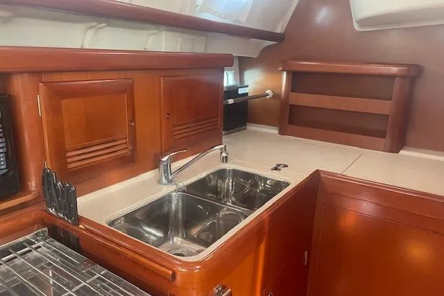 Plein Air Yacht Photos Pics 2006 Beneteau 423 yacht kitchen with wooden cabinetry and stainless steel sink.