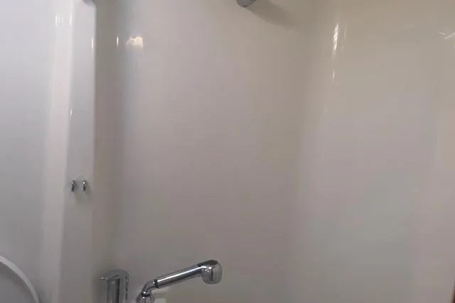 Plein Air Yacht Photos Pics Interior shower area of a 2006 Beneteau 423 yacht, featuring sleek white walls.